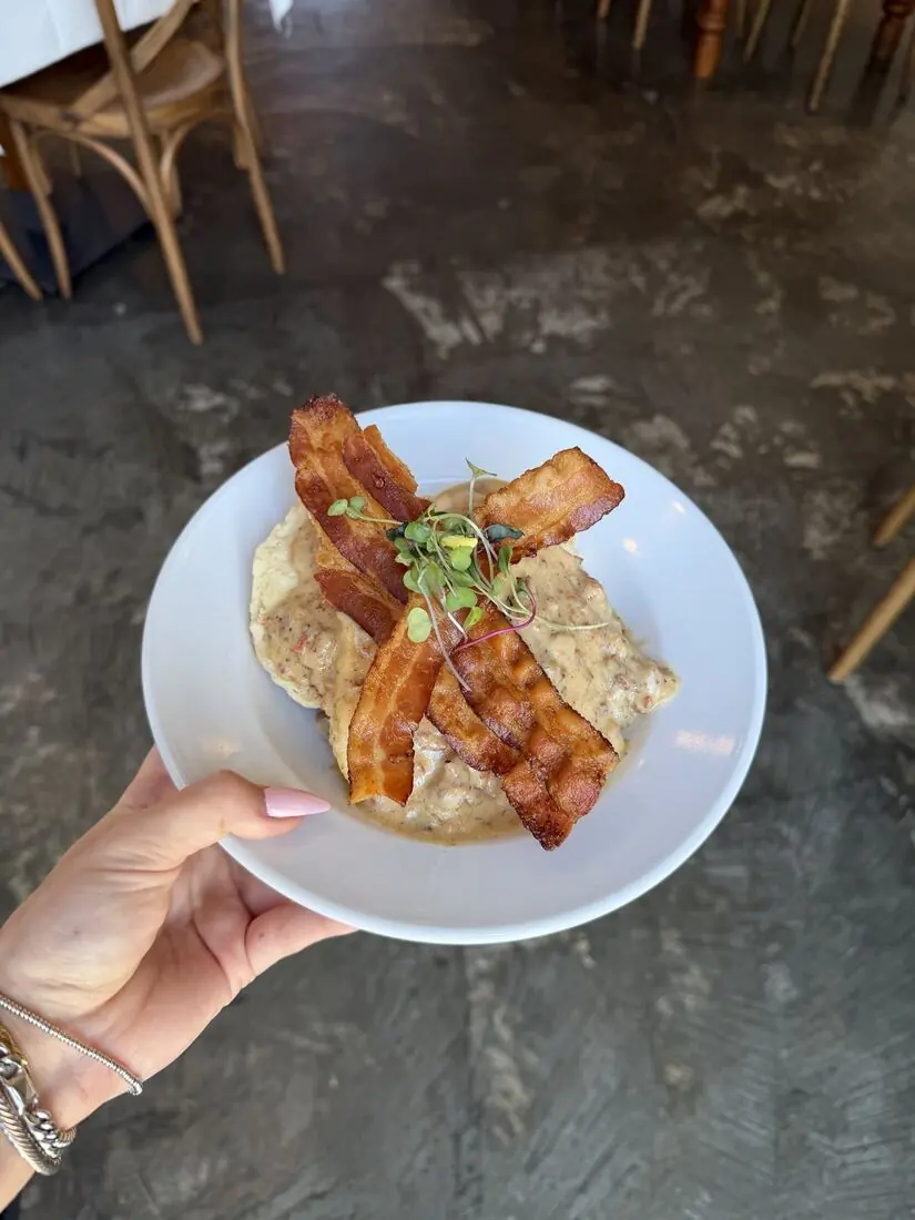 Biscuits and sausage gravy topped with bacon