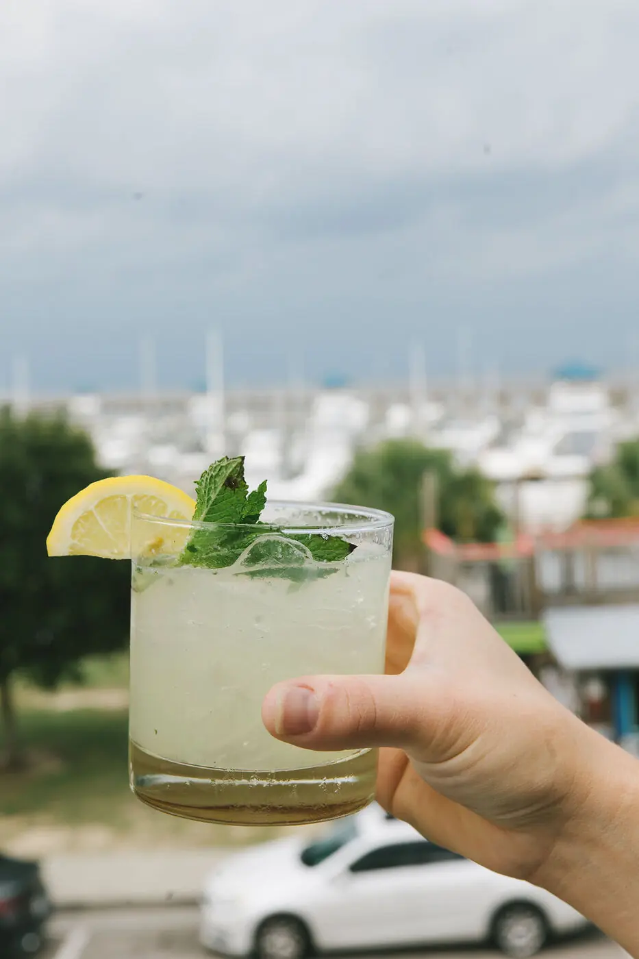 A cocktail raised toward the harbor