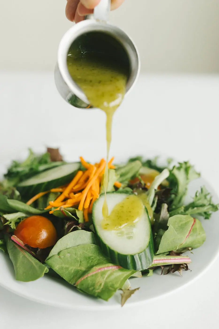 Dressing poured over a house salad